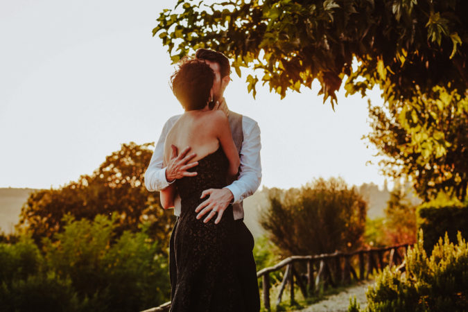 sposi che si abbracciano teneramente all'ombra di un grande albero